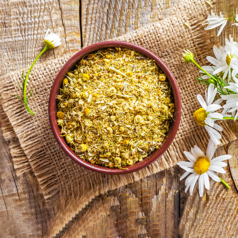 dried chamomile in a bowl and chamomile flowers on the side, rustic vibe for medicinal herbs