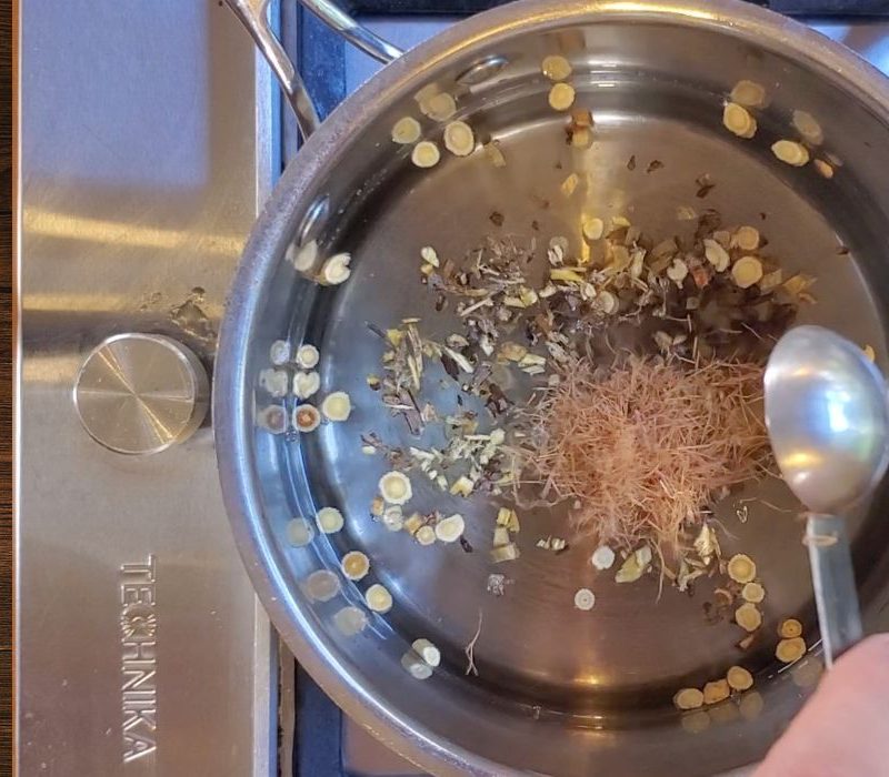 Pot with tonic herbs on stovetop.